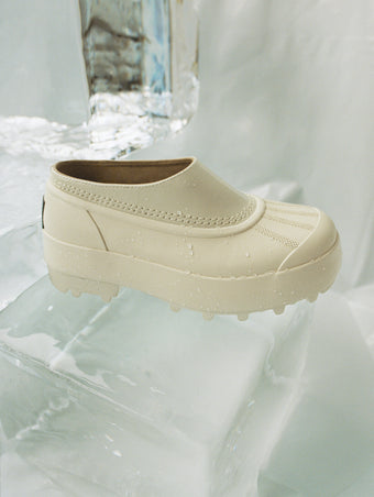 Image of SOREL x Proenza Schouler Caribou Mule in Chalk / Black sitting on block of ice