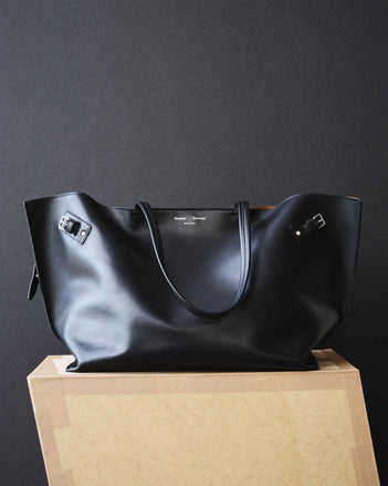 Days Carryall in Smooth Calf in black on cardboard platform