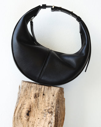 Mini Slide Bag in black on wooden platform