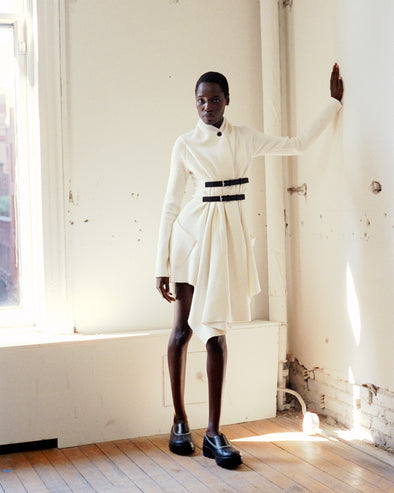 Model wearing Reinhardt Dress in Wool Cashmere in off white and SOREL x Proenza Schouler Caribou Mules in black/chalk