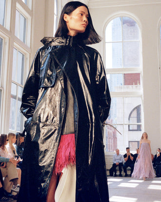 Model walking Proenza Schouler SS25 Runway show wearing Sabina Coat in Lacquered Leather in black