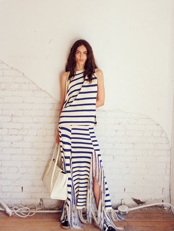 Model wearing Yves Top and Skirt in Stripe Fringed Knit in pale yellow multi, carrying Tate Bag in ecru