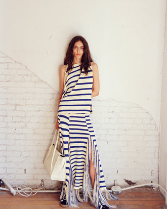 Model wearing Yves Top and Skirt in Stripe Fringed Knit in pale yellow multi, carrying Tate Bag in ecru