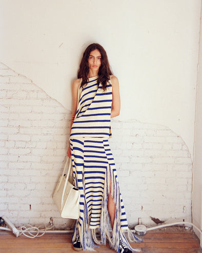 Model wearing Yves Top and Skirt in Stripe Fringed Knit in pale yellow multi, carrying Tate Bag in ecru