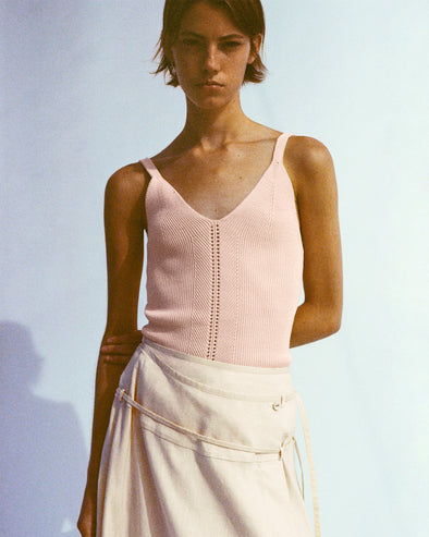 Model wearing Gene Knit Tank Top in Picot Cotton in light rose with Jovie Wrap Skirt in Linen Slub in light wheat, holding her arm tucked behind her back