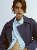Portrait of model wearing Sakia Coat in Wool Melange in Denim over light blue button up top