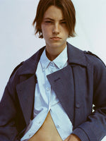 Portrait of model wearing Sakia Coat in Wool Melange in Denim over light blue button up top