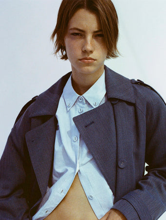 Portrait of model wearing Sakia Coat in Wool Melange in Denim over light blue button up top