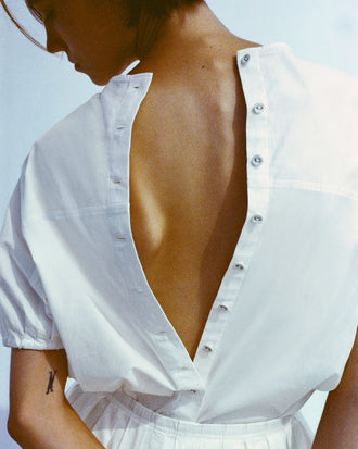 Cropped image of model's back wearing Haleigh Top in Cotton Sateen in white with buttons open down her back