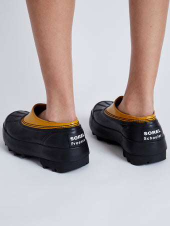 Proenza Schouler image of model wearing SOREL x Proenza Schouler CARIBOU Mule WP in GOLDEN OCHRE/BLACK