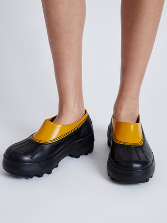 Proenza Schouler image of model wearing SOREL x Proenza Schouler CARIBOU Mule WP in GOLDEN OCHRE/BLACK