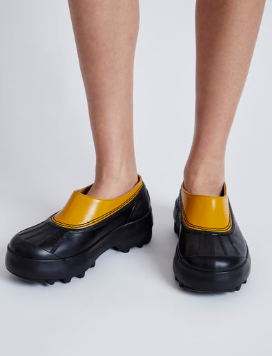 Proenza Schouler image of model wearing SOREL x Proenza Schouler CARIBOU Mule WP in GOLDEN OCHRE/BLACK