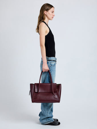 Front image of model wearing Tate Bag in Smooth Calfskin in dark red