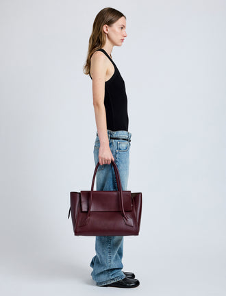 Front image of model wearing Tate Bag in Smooth Calfskin in dark red