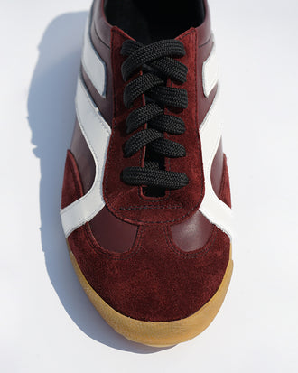 Cropped aerial image of Track Sneakers in colorway Oxblood and ivory stripes.