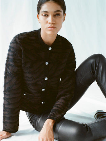 Image of model sitting on the floor, wearing Josephine Jacket in Brushed Knit in hickory/black
