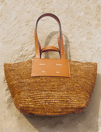 Aerial image of Large Morris Raffia Bag in honey on stucco