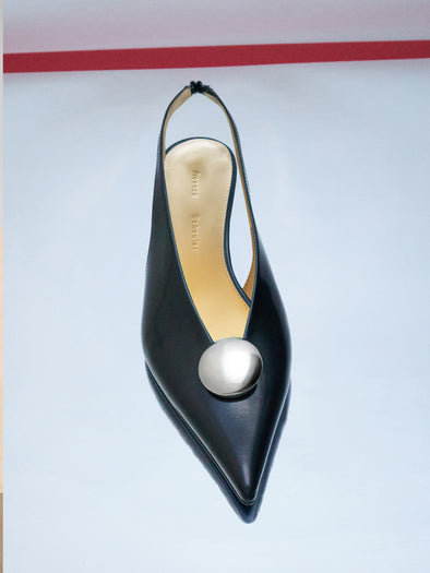 Editorial image of Dome Slash Slingbacks in Polished Calf in Black