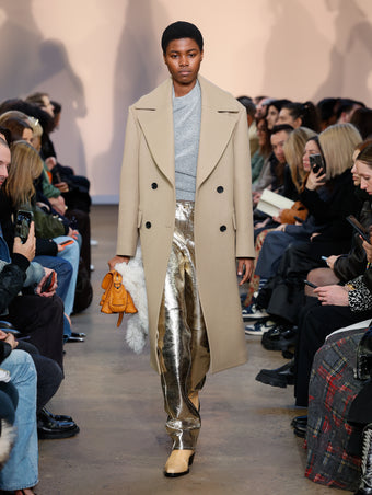 Model in Khaki Bonded Wool Felt Coat, Grey Melange Viscose Wool Sweater, Pale Gold Metallic Leather Pant, Natural Bronco Ankle Boots, Ginger Beacon Saddle Bag, Natural Shearling Scarf