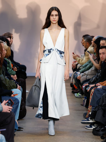 Model in White Printed Viscose Crepe Dress, Stone Cone Ankle Boots, and Slate XL PS1 Tote