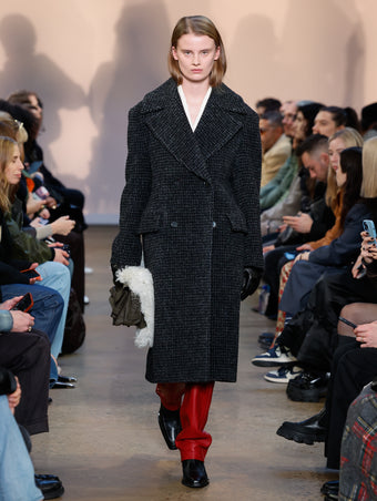 Model in Charcoal Melange Wool Boucle Coat, Bone Wool Twill Jacket, Crimson Nappa Leather Pant, Black Bronco Ankle Boots, Olive Beacon Saddle Bag, Black Leather Gloves, and Natural Shearling Scarf