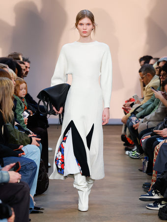 Model in Ivory Viscose Boucle Knit Dress, Black Printed Viscose Crepe Skirt, Cream Cone Over The Knee Boots, and Black L PS1 Tote