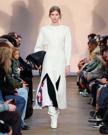 Model in Ivory Viscose Boucle Knit Dress, Black Printed Viscose Crepe Skirt, Cream Cone Over The Knee Boots, and Black L PS1 Tote