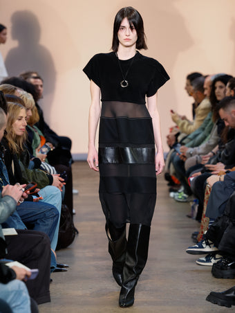 Model in Black Multi-Media Dress, Black Cone Boots, and Gold/silver Ring Necklace