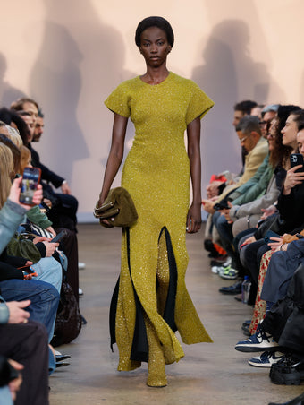 Model in Chartreuse Technical Sequin Knit Dress, Black Wool Felt Skirt, Chartreuse Technical Sequin Knit Over The Knee Boots, and Olive Shearling Bar Bag
