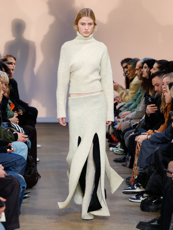 Model in Ecru Technical Sequin Knit Sweater, Ecru Technical Sequin Knit Skirt, Black Wool Felt Skirt, and Ecru Technical Sequin Knit Over The Knee Boots