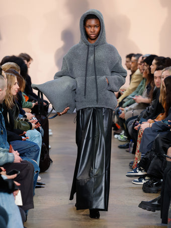 Model in Grey Technical Boucle Knit Hoodie, Black Nappa Leather Dress, Black Cone Ankle Boots, and Slate Felt XL PS1 Tote