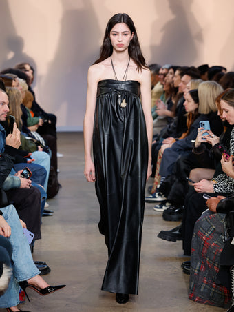 Model in Black Nappa Leather Dress, Black Cone Ankle Boots, Silver/gold Horn Pendant Necklace, and Gold Rock Pendant Necklace