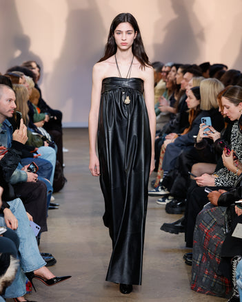 Model in Black Nappa Leather Dress, Black Cone Ankle Boots, Silver/gold Horn Pendant Necklace, and Gold Rock Pendant Necklace
