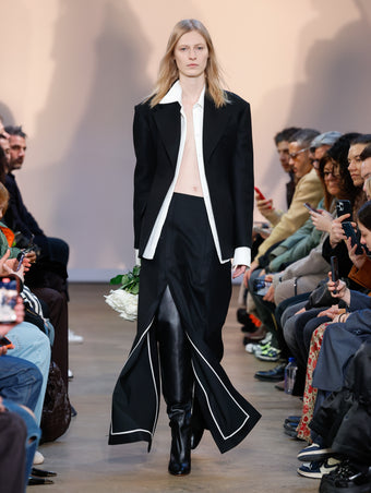 Model in Black Wool Felt Jacket, White Crushed Matte Satin Shirt, Black Wool Felt Skirt, and Black Cone Over The Knee Boots