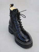 Proenza Schouler 3/4 front editorial image of Lug Sole Lace-up Boots in BLACK