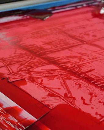 4x5 image of the red Ondine dress being garment printed in the factory