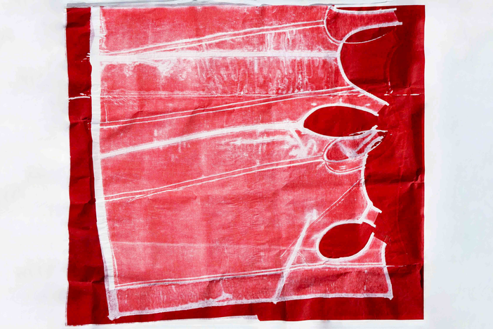 Ondine Dress in Garment Printed Silk Viscose in process, image of fabric printed in red dye before pattern is cut